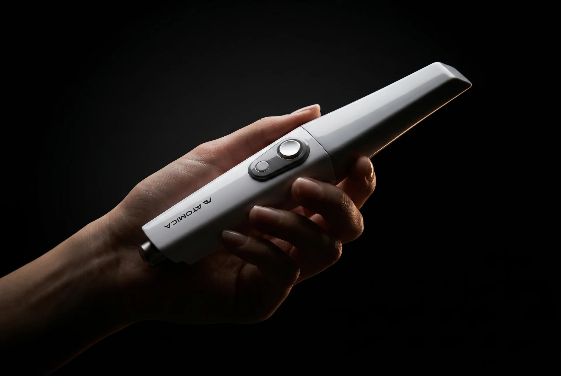 Atomica S400 scanner balanced on a fingertip — 160 grams